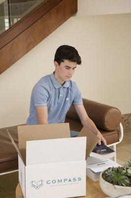 Student opening their materials package.