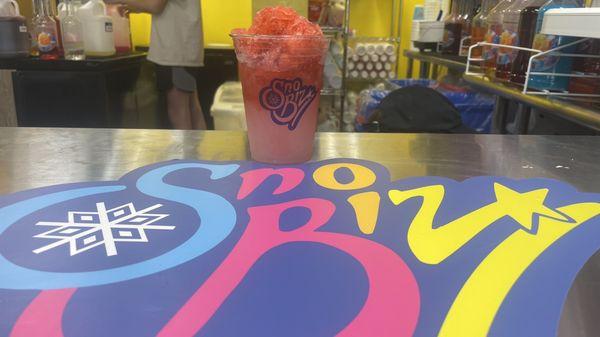 Pink Lemonade Slush topped with shave ice and your flavor choice. $4 +tax