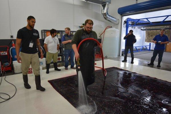 Flushing a modern Iranian carpet with loose dyes during a training event.