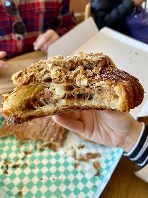 Inside of twice-baked pecan + oat croissant-- filled and topped with to-die-for filling that makes it almost like biting into a pecan pie