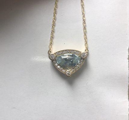 Custom cut trillian cut aquamarine from our Africa trip. Set in custom made diamond necklace.