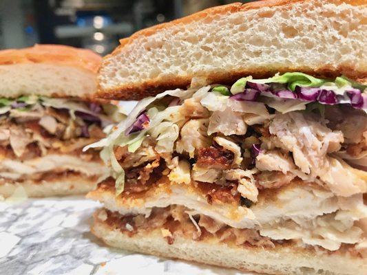 Buttermilk fried chicken, shredded roasted chicken thigh, crunchy slaw, house spread, on a toasted, buttered King Hawaiian bun.