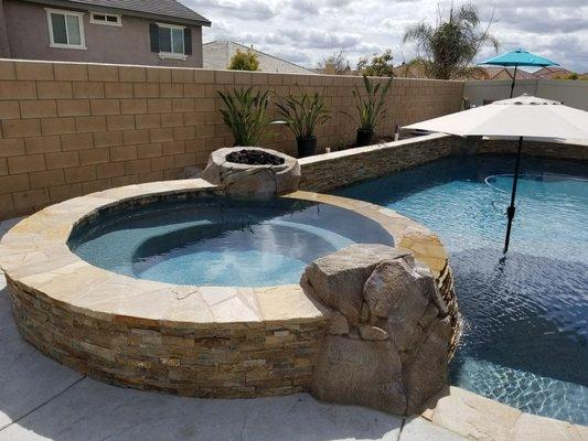 9ft spa with taperd side rock spillway. Fire bowl