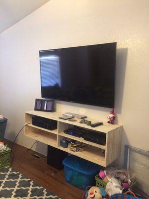 Tv mounted, wires ran in wall, texture, prime and paint, and he even built us a mounted entertainment center.