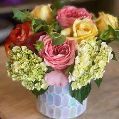 Elevate your space with elegant roses and hydrangeas in a stunning lavender cut glass vase. A timeless arrangement for any occasion.