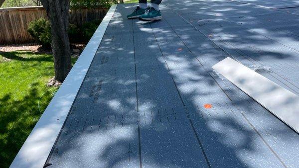 The gutter apron is installed in between the layers of Modified Bitumen.