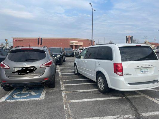 Example of cars parked illegally. One on the lines, and the black Jeep did not have any placards displayed either.