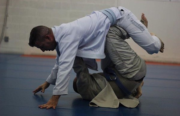 Head Instructor elevating training partner for a leg lock entry