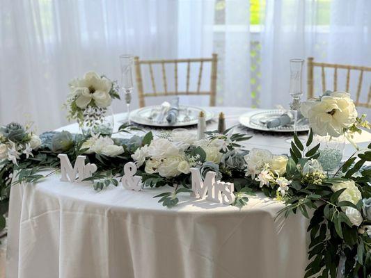 Mr and Mrs sweetheart table decor with background curtains at a wedding.