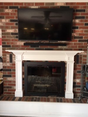 Fabricating a new mantle and hanging a TV helps bring this brick wall up to date