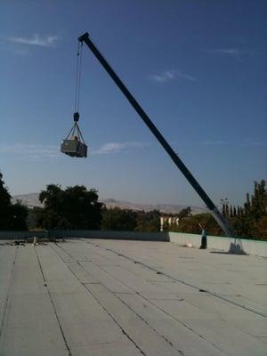 No job too big or small! This crane is lifting a 3-ton unit onto a warehouse!