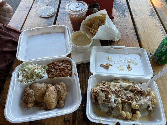 Left: Single meal plate with chicken, coleslaw, and cowboy beans. Right: Loaded baked potato with pulled pork, mac 'n cheese, and queso