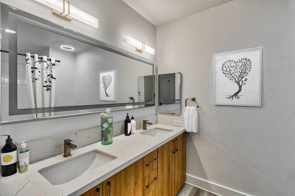 Newly renovated bathroom featuring double vanity and LED mirror.