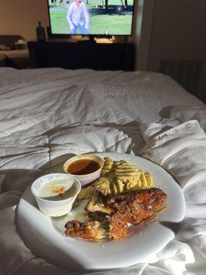 Wings and fries in bed.