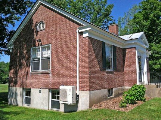 A Mitsubishi Electric outdoor unit mounted on brackets to the Meriden NH library.