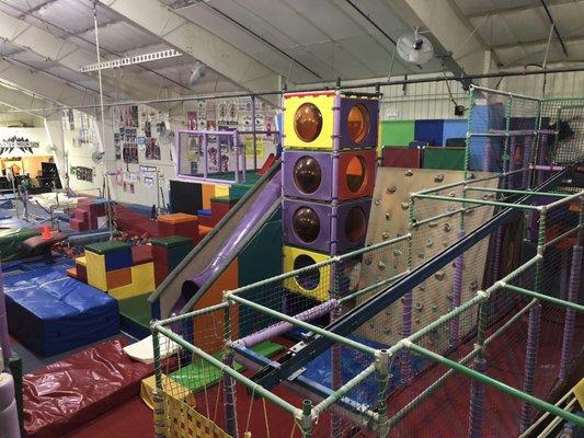 Climbing structure, foam pit, and zip line