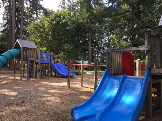 Playground with varieties of toys including a picnic shelter in the shade.