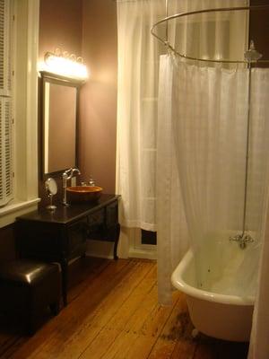 Newly renovated bathroom features clawfoot tub with extra large shower enclosure