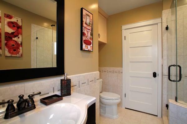 Porcelain flooring &1/2 walls w/glass ribbon, wood vanity & porcelain sink, custom wood shaker style door with custom casement