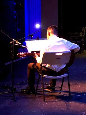 Guitar student reading music at performance