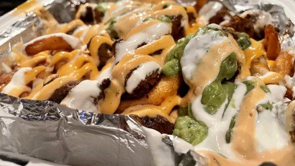 SoCal Asada fries: curly fries, cheese, sour cream, guacamole, cilantro, grilled onions, grilled jalapeno, and sauce. $16.95.