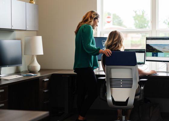 Our Vice President of Marketing, Becca Cochrane (left), working with our Web & Graphic Designer, Emily Prince (right).