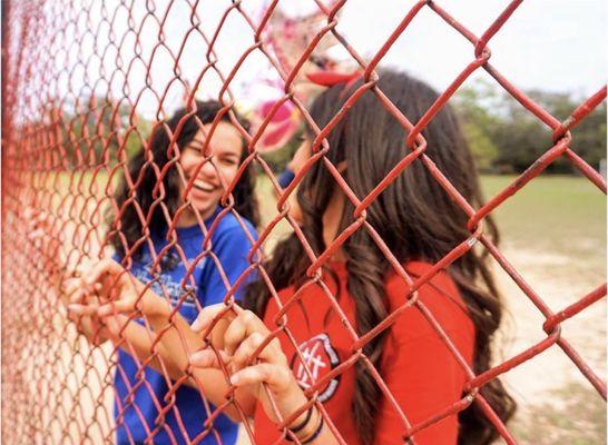 Friends laughing behind a fence