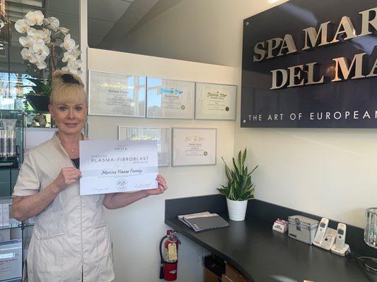 Our beautiful Marina along with just a few of her certifications. She's holding her latest for plasma - fibroblast skin tightening.