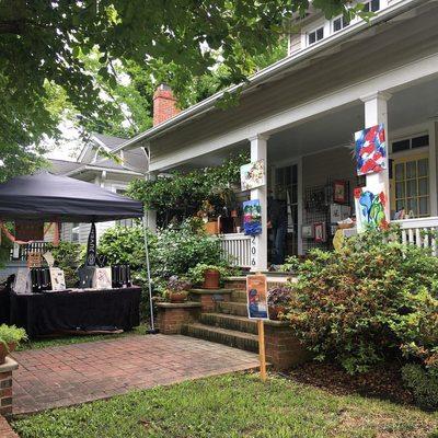 A front porch and lawn hosting artists on Franklin Street in Historic Oakwood