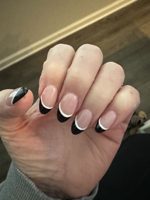 Almond Shaped acryllic nails with black and white polished tips.