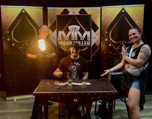 Mark Miller with me and my partner posing for a photo by his table set up.