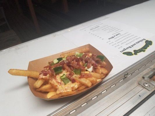 These fries are topped with queso, chopped crispy bacon and jalapenos