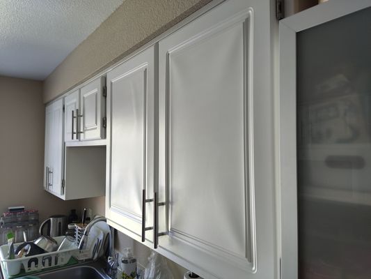 This isn't an optical illusion - the 'luxury' cupboards are just old, poorly-refaced cheap cupboards.