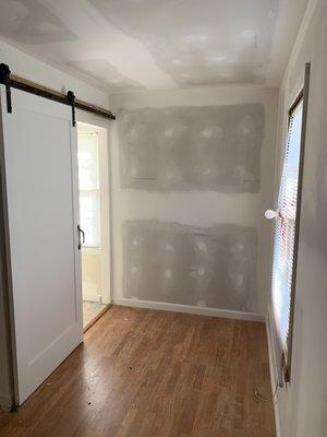 Closet taken out in corner and repositioned the door opening to install barn door.