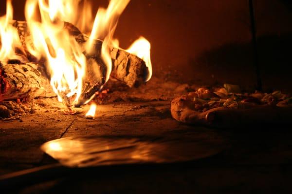 Pizza cooking in our mobile wood oven.