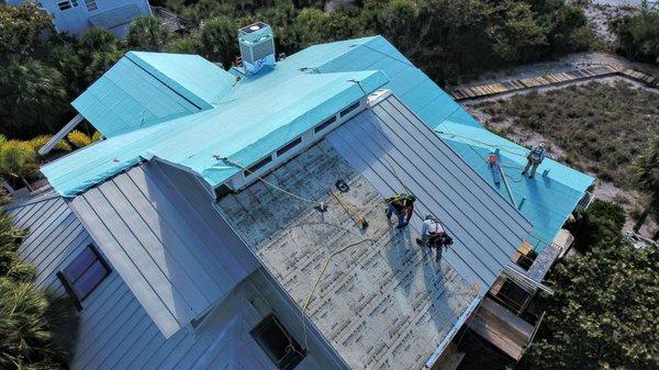 In progress shot of us removing of an existing metal roof and installing the new underlayment for a new metal roof.