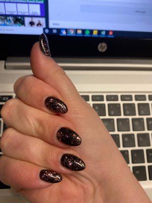 Black nails with pink glitter overlay.