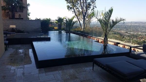 Infinity pool with striking travertine decking.