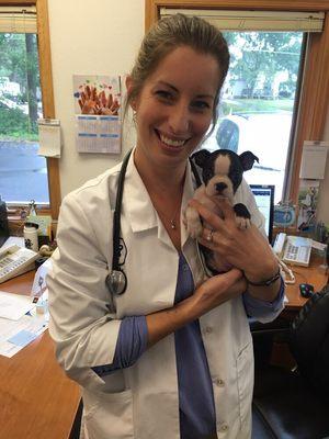 Dr. Christina cuddling a very young Boston Terrier puppy.