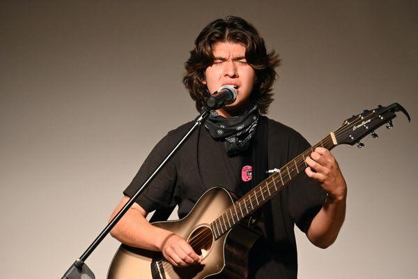 Rocking out with his original song that he wrote.