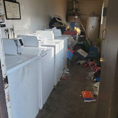 Laundry Room #2. See all the junk piled around the hot water heaters.