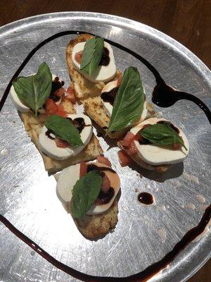 bruschetta with fresh mozzarella cheese, tomatoes, basil, and a drizzle of balsamic