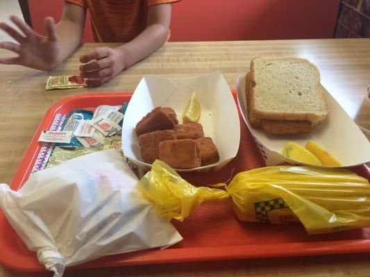 My fish sandwich and fish nuggets with fries and corn on the cob.