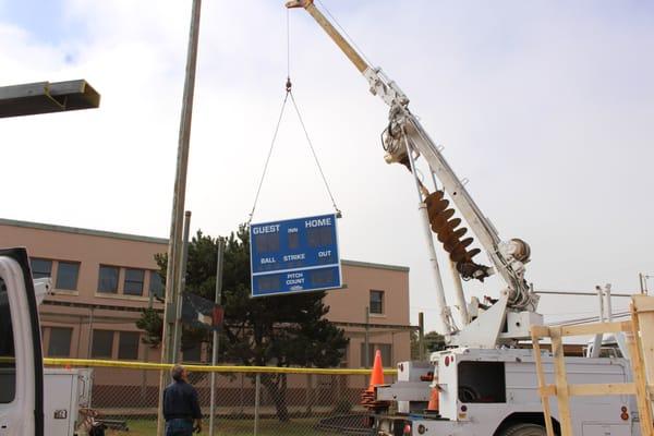 Hanging the new scoreboard sign at Pike Field!