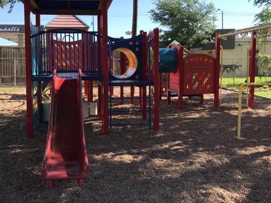 Well shaded play scape. With a nice thick layer of pea gravel below. Lots of room to run.