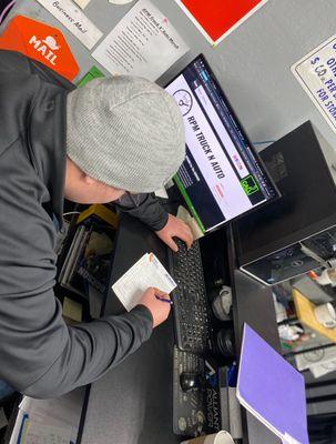 Steven (Shop Foreman) talking to a customer and writing down notes about the phone call, hoping to get another job sold!