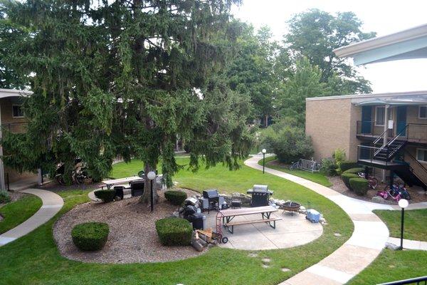 Beautiful landscaping featuring mature trees and shady seating areas.