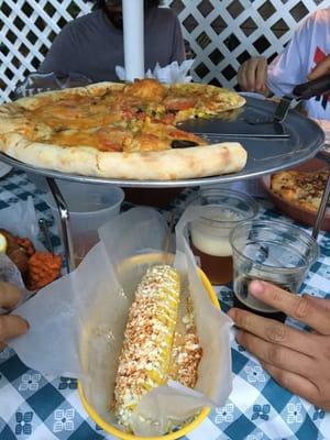 Frye Island Fuego pizza and corn on the cob with cheese, lime, and chili powder (Mexican street corn).