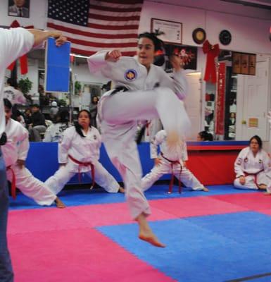 Ana Maria Blanco breaks a board during her test for 3rd-degree black belt.