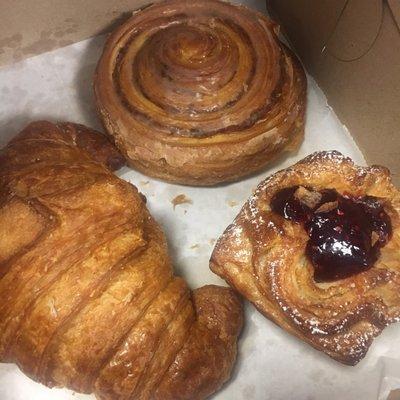 Croissant, cinnamon roll and a raspberry cruffin